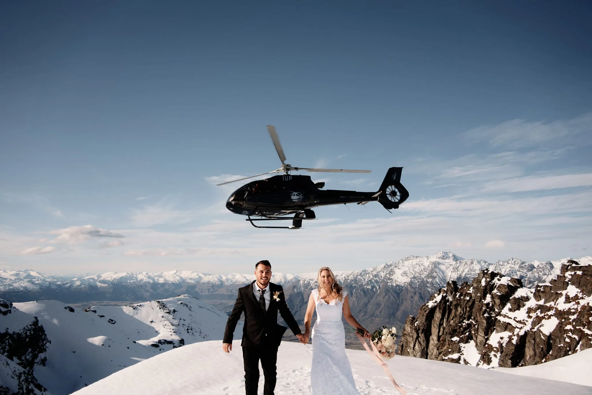 クイーンズタウン　ニュージーランド　ウェディング　前撮り　挙式　結婚式　フォトグラファー | 雪山の頂上でクイーンズタウンのヘリウェディング＆エロープメントパッケージに参加する新郎新婦。